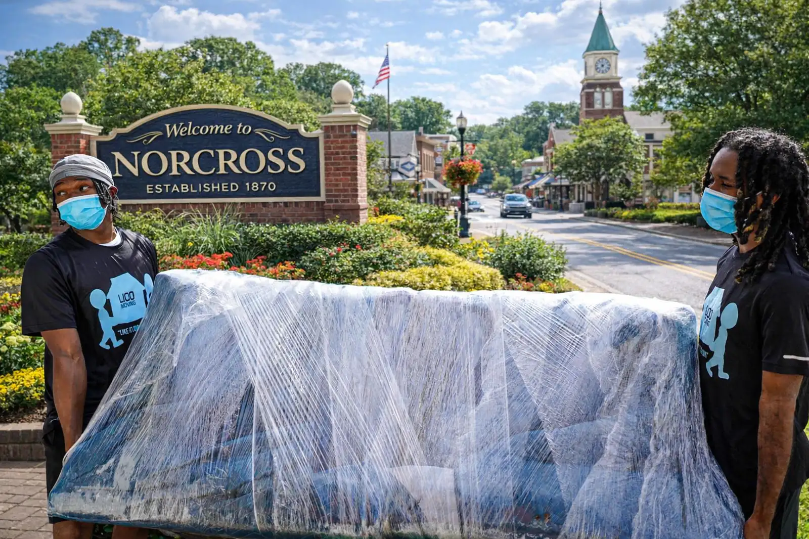 LIOO Moving crew wrapping and carrying a couch near downtown Norcross, Georgia during a local move