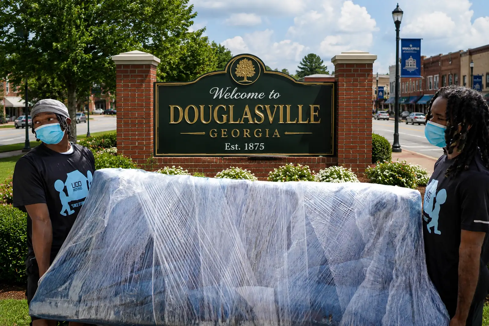 LIOO Moving crew carrying shrink-wrapped furniture during a residential move in Douglasville, Georgia