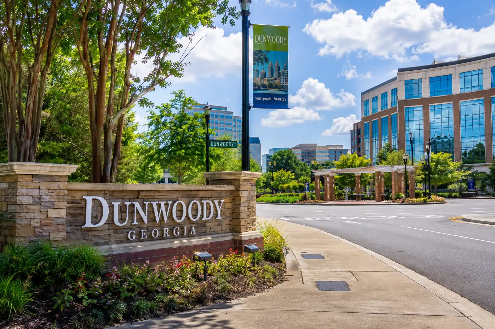 Dunwoody Georgia monument sign beside a landscaped roadway and modern office buildings