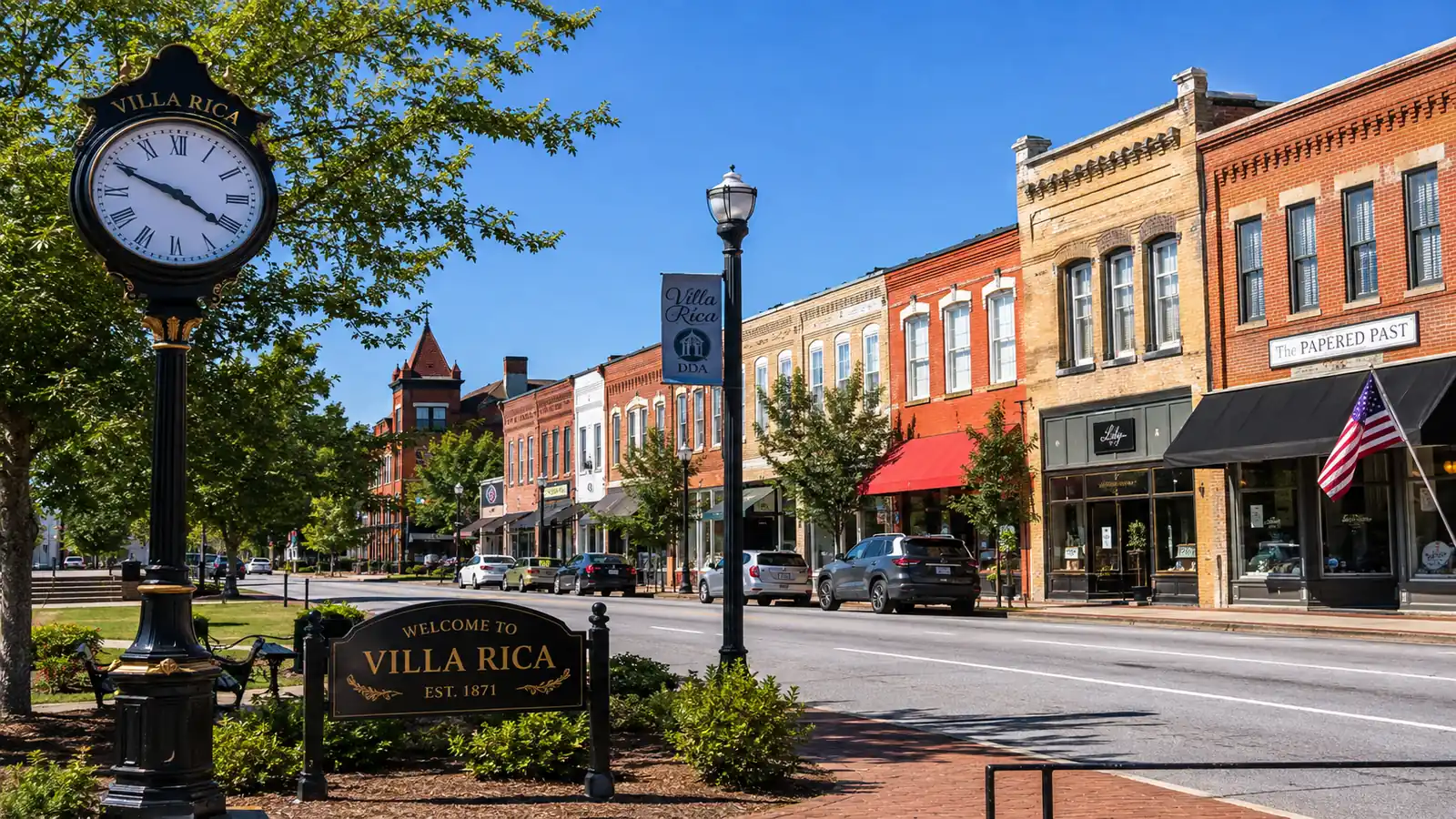 Historic brick storefronts line a downtown Villa Rica street beside a welcome sign and street clock